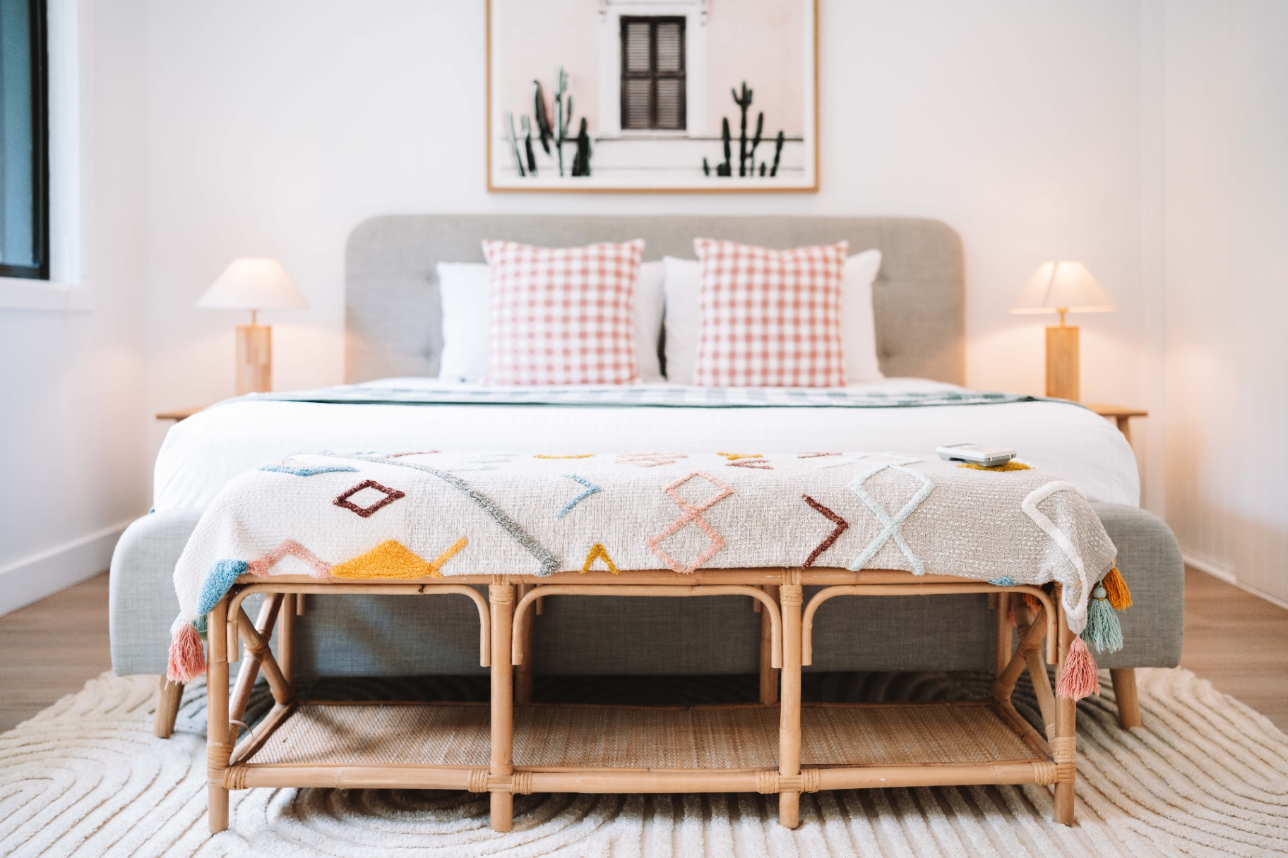 Main bedroom at Hjemme Noosa with king bed, soft lamps and coastal styling.