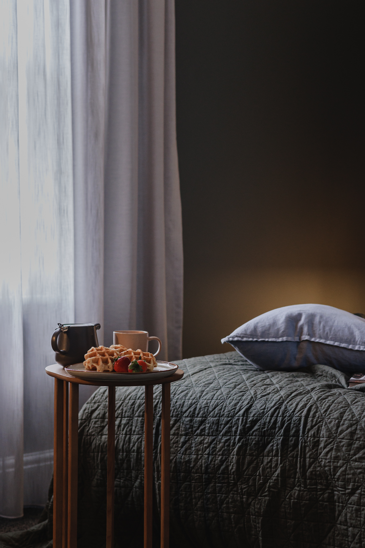 Bedroom breakfast photo with waffles, coffee, soft curtains and dark bedding at Hjemme Hobart