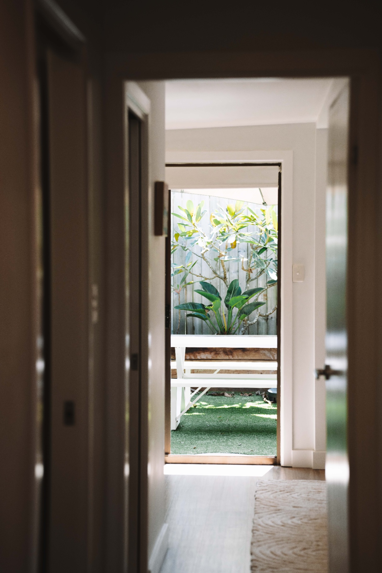 Hallway at Hjemme Noosa looking out to the private outdoor area and tropical garden.